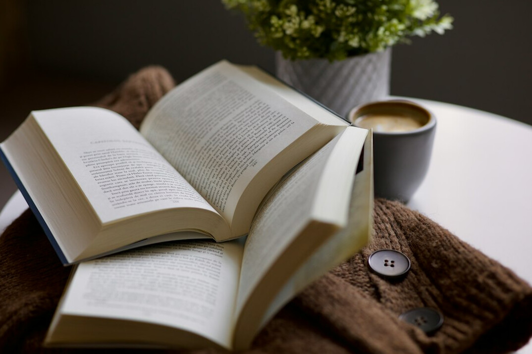 Open book next to a cup of coffee
